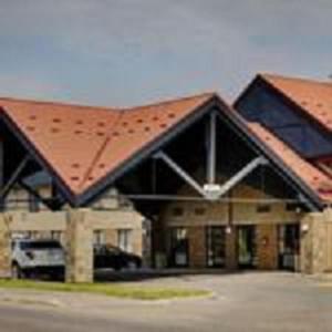a large brick building with a red roof at Thompson's Best Value Inn & Suites in Thompson