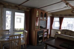 a living room with a television and a table and chairs at Caravan 6 Berth North Shore Holiday Centre with 5G Wifi in Winthorpe