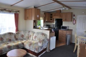 a living room with a couch and a kitchen at Caravan 6 Berth North Shore Holiday Centre with 5G Wifi in Winthorpe