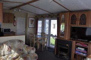a living room with a couch and a table with chairs at Caravan 6 Berth North Shore Holiday Centre with 5G Wifi in Winthorpe