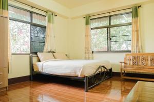 a bedroom with a bed and two windows at หลินฝูเอิน Ling Fu En in Mae Salong +12 photos