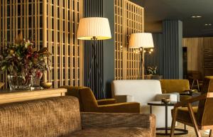 a hotel lobby with chairs and tables and lamps at Lodge Park Hotel & Spa in Soldeu +49 photos
