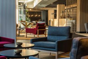 a lobby with couches and chairs and tables at Lodge Park Hotel & Spa in Soldeu