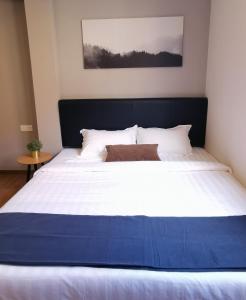 un grande letto con lenzuola bianche e una coperta blu di The Core Hotel a Subang Jaya