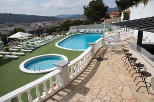 a view of a pool with chairs and tables at Hotel - Bungalows Don Juan Tossa in Tossa de Mar
