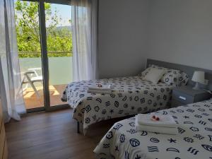 パラモスにあるApartament La Fosca Palamósのベッドルーム1室(ベッド2台付)、バルコニーが備わります。