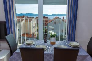 a dining room table with a view of a window at Adriana's Dream View 2 bedrooms apartment in Zadar