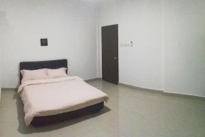 a bedroom with a bed in a white room at HomezStay Airport Miri in Miri