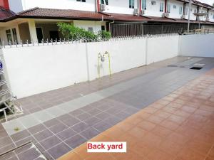 a patio with a white fence and a sidewalk at HomezStay Airport Miri in Miri