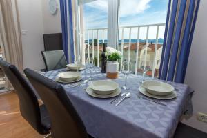 a dining room table with a blue table cloth and chairs at Adriana's Dream View 2 bedrooms apartment in Zadar