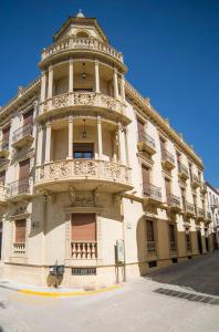 a large building with a tower on a street at CASA DEL CIRCULO MERCANTIL in Villanueva del Arzobispo