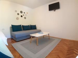 a living room with a blue couch and a table at Brana Gorica Apartments in Trebinje