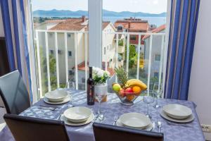 a table with a bowl of fruit on a table with a window at Adriana's Dream View 2 bedrooms apartment in Zadar