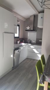 a kitchen with white cabinets and a table and chairs at Gîte de charme in Mirabel-aux-Baronnies