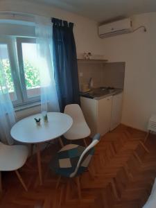 a small kitchen with a table and a table and chairs at Brana Gorica Apartments in Trebinje