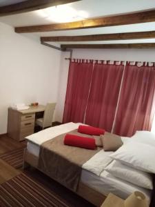 1 dormitorio con 1 cama con cortina roja en Guest House Šumski dvor en Vrhovine