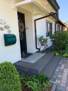 un porche delantero de una casa con una puerta verde en Ferienwohnung-Am-Sternbusch en Hau