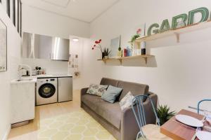 a living room with a couch and a kitchen at Design Apartment for 4 people between Louvre & Opera in Paris