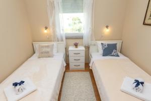 two twin beds in a small room with a window at Adriana's Dream View 2 bedrooms apartment in Zadar