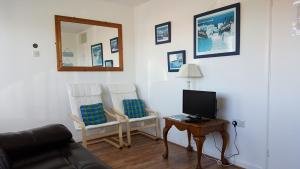 a living room with a couch and a table and a mirror at 151 Perran Sands in Perranporth