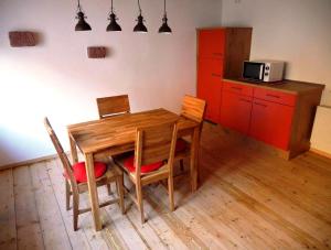 a kitchen with a wooden table and chairs and red cabinets at Ferienhaus In der Erlebach in Elmstein