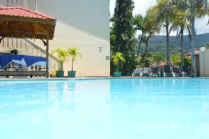 una gran piscina azul con sillas y árboles en Coco D'or Hotel Seychelles en Beau Vallon