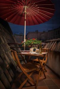 a table and chairs with an umbrella on a balcony at Vincent Restauracja&Apartamenty in Wrocław