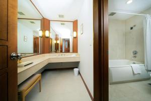 
a bath room with a sink and a bath tub at Jeju KAL Hotel in Jeju
