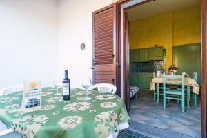 una cocina con una mesa con una botella de vino. en Residenza Gli Ontani, en Orosei