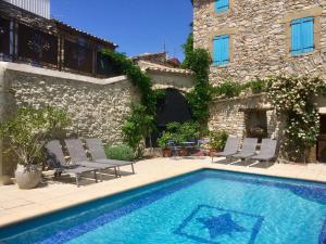 a house with a swimming pool in front of a building at L'Autre Maison in Saint-Jean-de-Ceyrargues