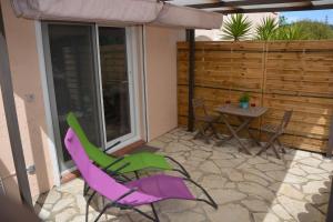 un patio con mesa, sillas y sombrilla en Appartement FredMart en Mougins