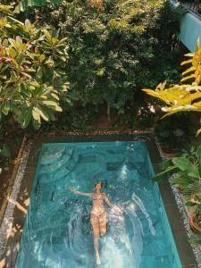 een man in een zwembad in een tuin bij Villa De Campagne Hoi An in Hội An