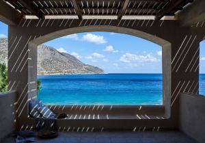 a view of the ocean through a window at Plaka Sea Front Residence in Elounda