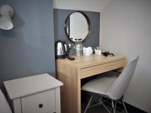 a dressing table with a mirror and a chair at Seaview House Bed and Breakfast in Larne