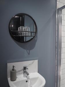 a bathroom with a sink with a mirror above it at Seaview House Bed and Breakfast in Larne