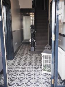 Seaview House Bed and Breakfast في لارن: مدخل مع أرضية بلاط سوداء وبيضاء