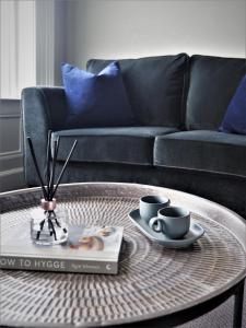 uma mesa de café com duas chávenas de café e um livro em Seaview House Bed and Breakfast em Larne