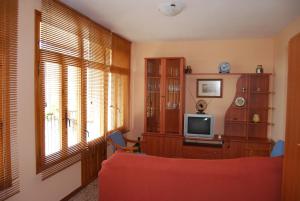 a living room with a red couch and a television at CASA LACAMBRA in Boltaña