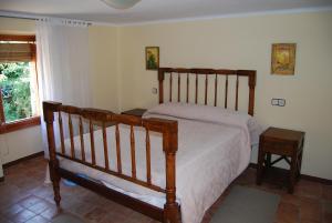 1 dormitorio con cama de madera y ventana en CASA LACAMBRA, en Boltaña