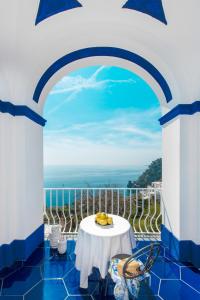 a table on a balcony with a view of the ocean at Imperati Suites by Alcione Residence in Positano