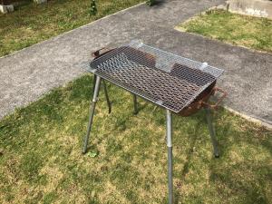 a grill sitting on the grass in a yard at Tokashiki Guest House in Tokashiki