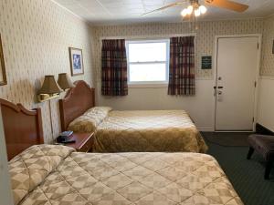 מיטה או מיטות בחדר ב-The Lionstone Inn Motel and Cottages