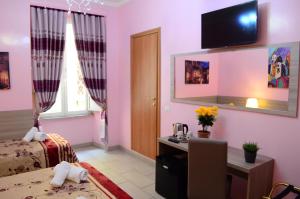 a bedroom with pink walls and a bed and a desk at Roma Castle Termini in Rome