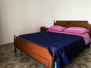 uma cama com almofadas cor-de-rosa e roxas em Appartamento a Villapiana Lido em Villapiana