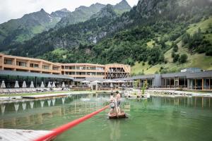 Ein paar Leute stehen auf einem Floß im Wasser. in der Unterkunft Feuerstein Nature Family Resort in Gossensaß