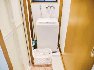 a small bathroom with a sink and a washing machine at Triphome Ikebukuro Tokyo Max 7ppls FREE WIFI in Tokyo