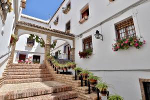 a building with stairs and potted plants at Rosas en la Balconada & Apartment with Parking in Córdoba Historic Center in Córdoba