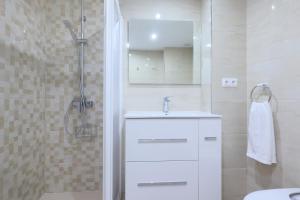 a white bathroom with a sink and a shower at Rosas en la Balconada & Apartment with Parking in Córdoba Historic Center in Córdoba +26 photos