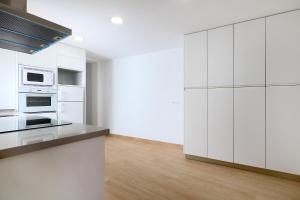 a white kitchen with white cabinets and appliances at Rosas en la Balconada & Apartment with Parking in Córdoba Historic Center in Córdoba