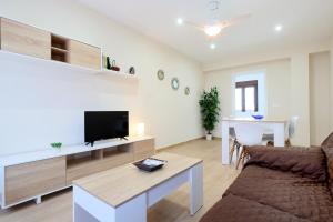 a living room with a couch and a flat screen tv at Rosas en la Balconada & Apartment with Parking in Córdoba Historic Center in Córdoba